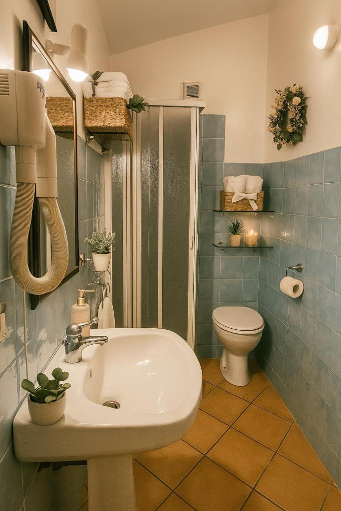 une salle de bain avec un lavabo et des toilettes dans l'établissement Hotel Poseidonia, à Sapri