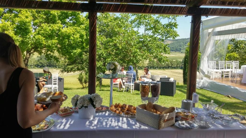 une table avec de la nourriture et des personnes assises dans l'herbe dans l'établissement Agriturismo Chieteno con piscina e AC- Cetona, à Cetona