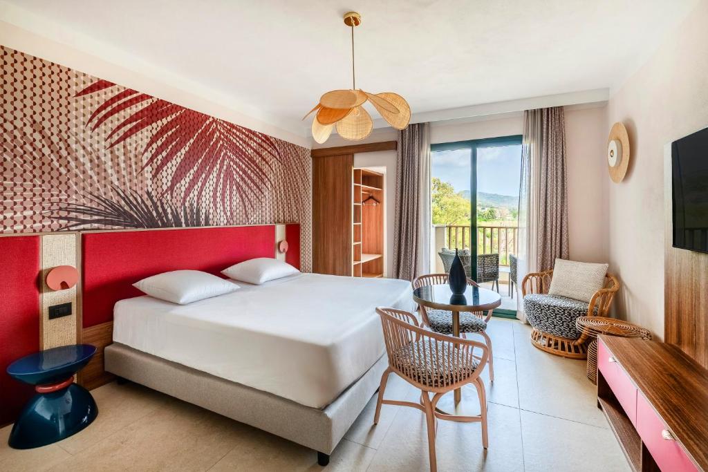 une chambre avec un lit et une table avec une chaise dans l'établissement VOI Tanka Selected, à Villasimius