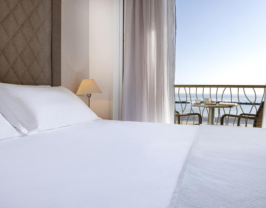 une chambre avec un lit et une vue sur l'océan dans l'établissement Hotel Riviera, à Bellaria-Igea Marina