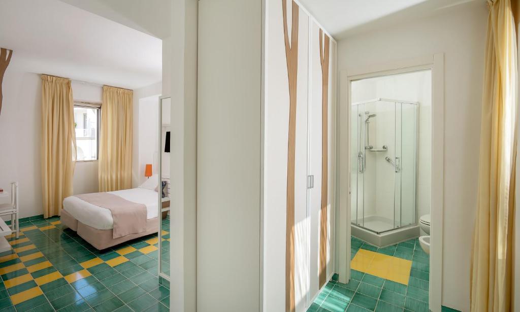 une chambre avec un lit et une salle de bain avec douche dans l'établissement Le Ancore Hotel, à Vico Equense