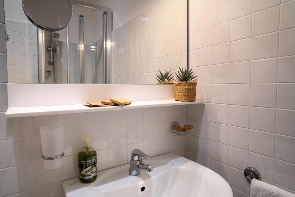 une salle de bain avec un lavabo et un miroir dans l'établissement Hotel Renania, à Bibione