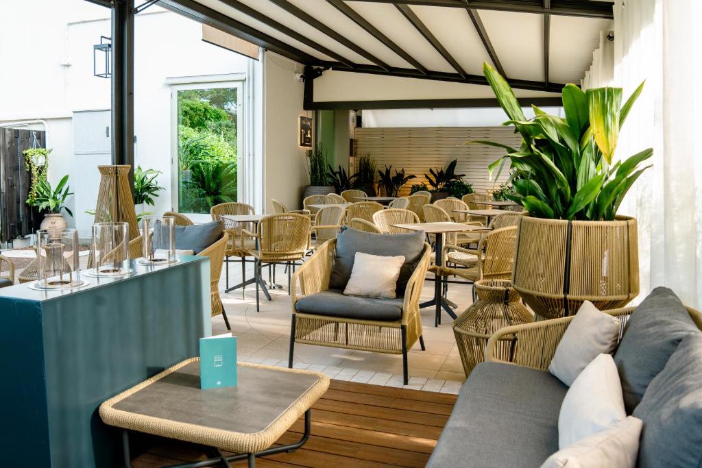 un restaurant avec des canapés, des tables et des chaises dans l'établissement Hotel Renania, à Bibione
