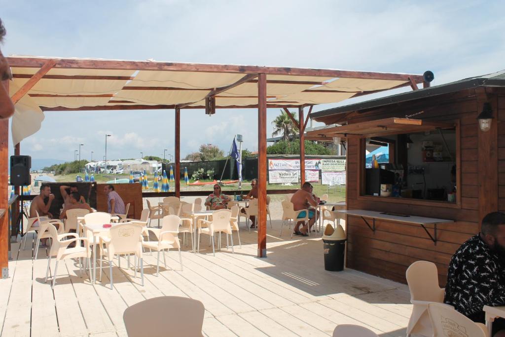 d'une terrasse avec un bar doté de chaises blanches et d'une connexion Wi-Fi gratuite. dans l'établissement Hotel South Paradise, à Palmi