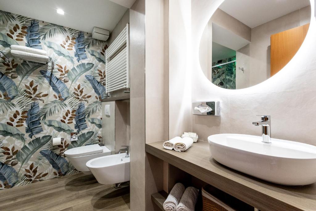La salle de bains est pourvue de 2 toilettes, d'un lavabo et d'un miroir. dans l'établissement Hotel Palm Beach B&B SEA VIEW, à Rimini