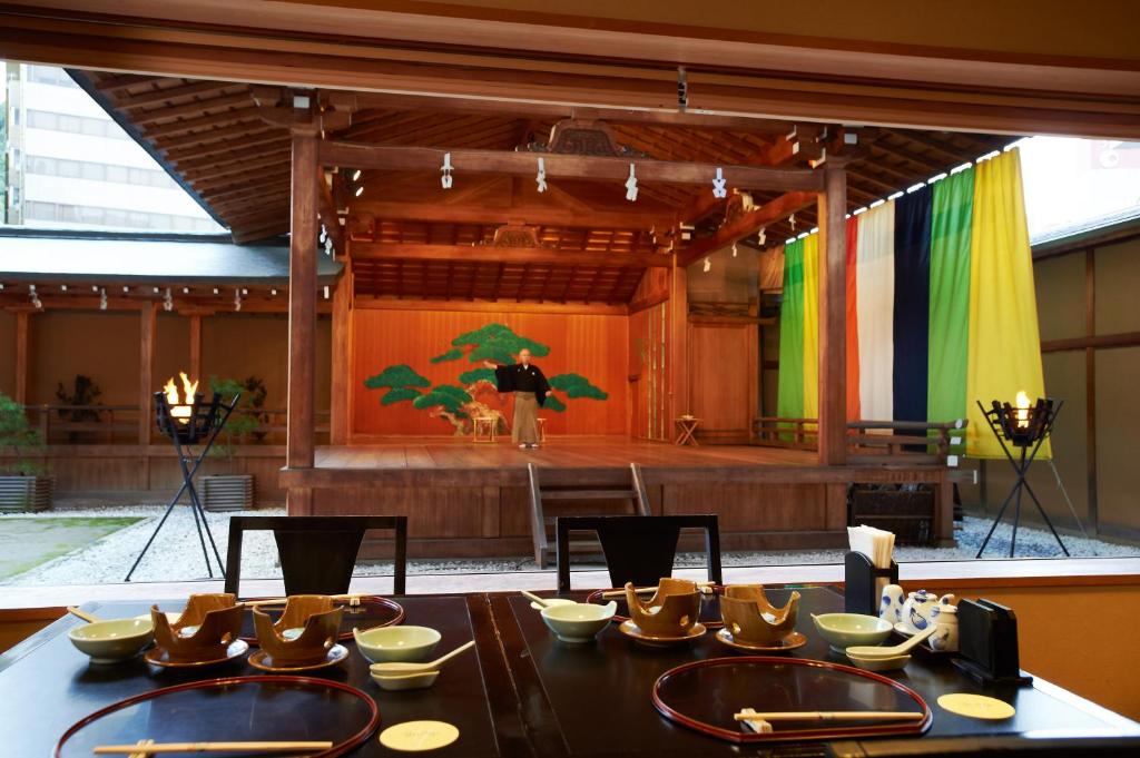 une salle à manger avec une table et une scène dans l'établissement Yamatoya Honten, à Matsuyama 37 autres photos