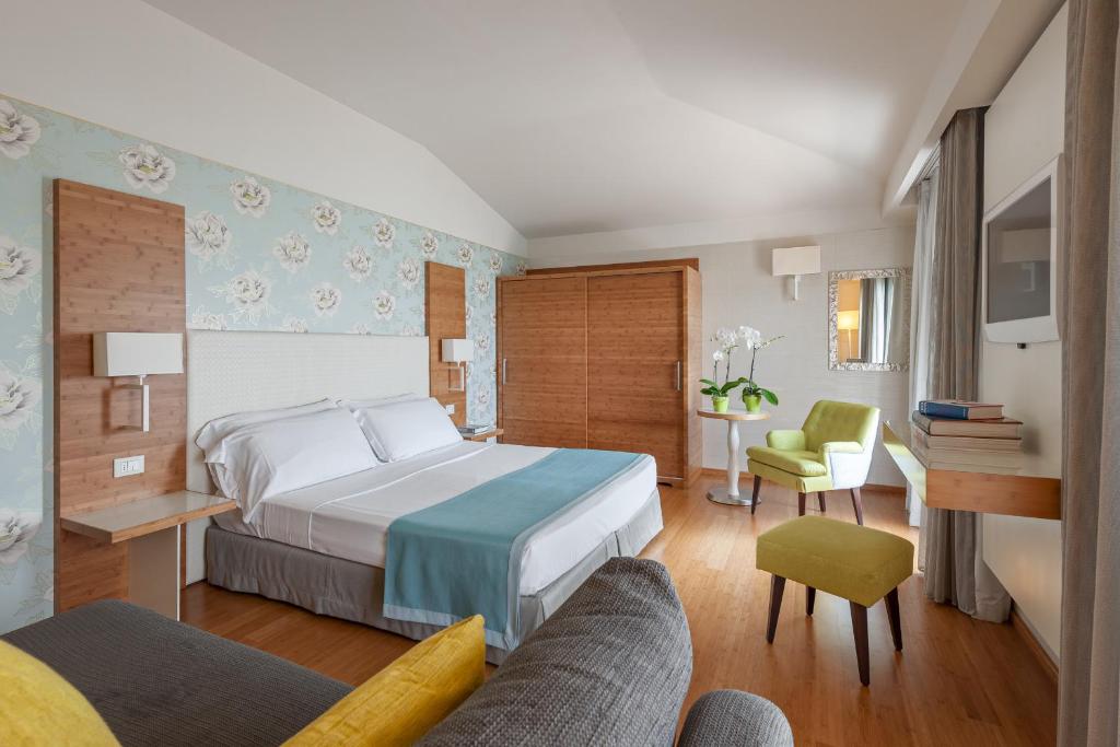 une chambre d'hôtel avec un lit et un canapé dans l'établissement Hotel Eden, à Sirmione