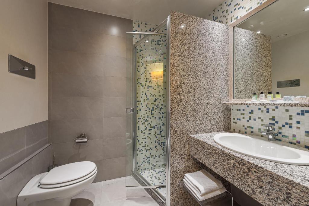 une salle de bain avec toilettes, lavabo et douche dans l'établissement Hotel Eden, à Sirmione