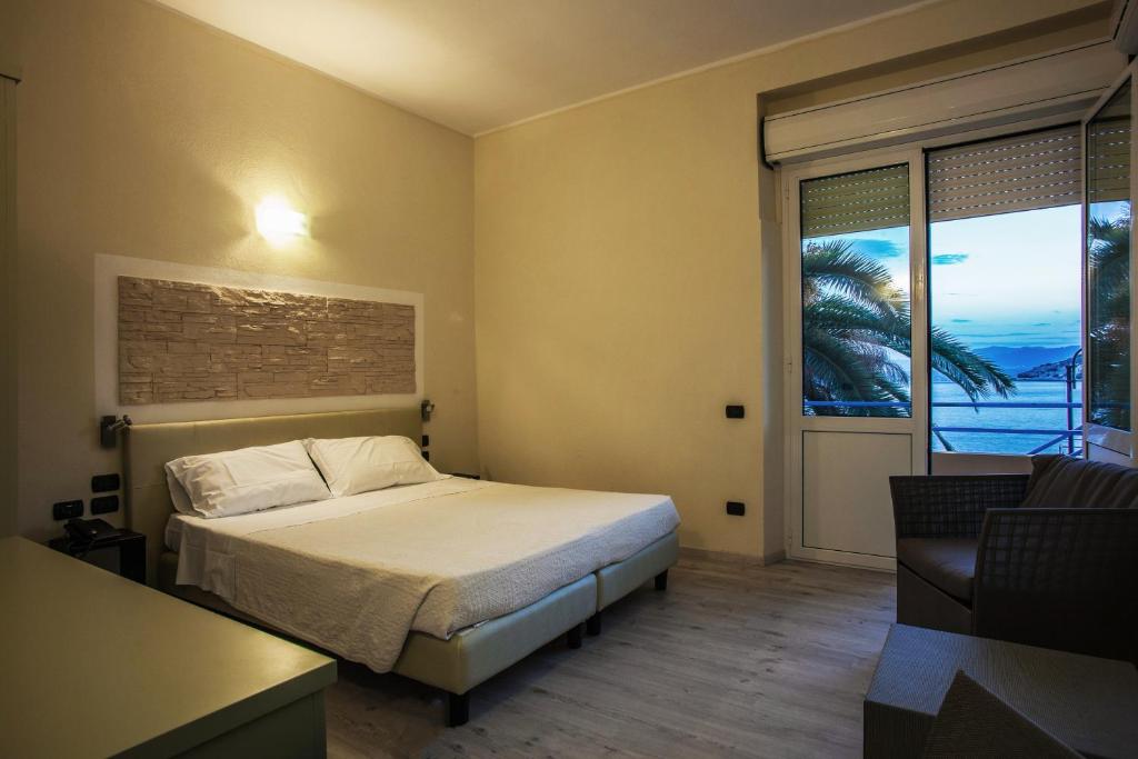 une chambre avec un lit et une vue sur l'océan dans l'établissement Hotel Calamosca, à Cagliari