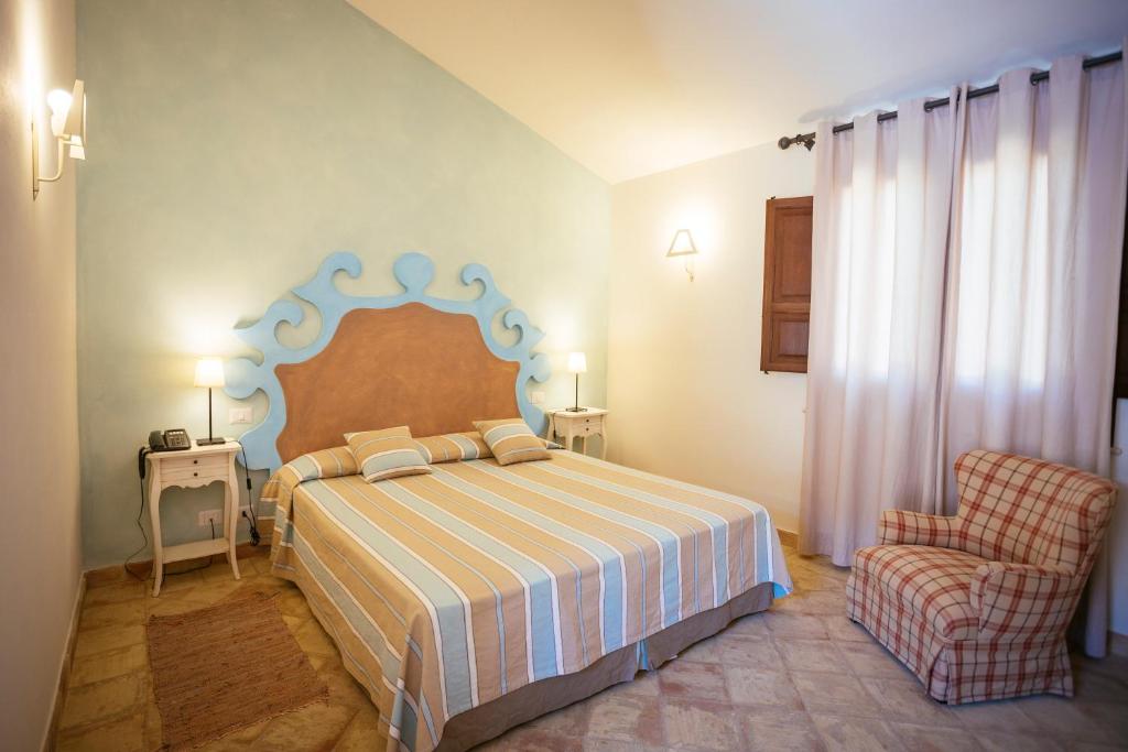 une chambre avec un lit et une chaise dans l'établissement Hotel Baglio Catalano, à Custonaci