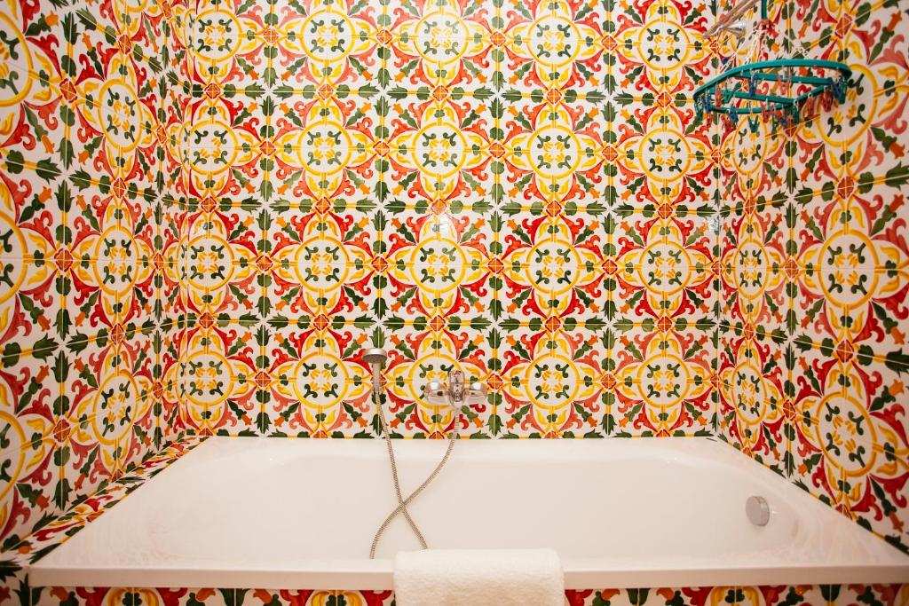 une salle de bain avec un mur carrelé avec une baignoire dans l'établissement Hotel Baglio Catalano, à Custonaci