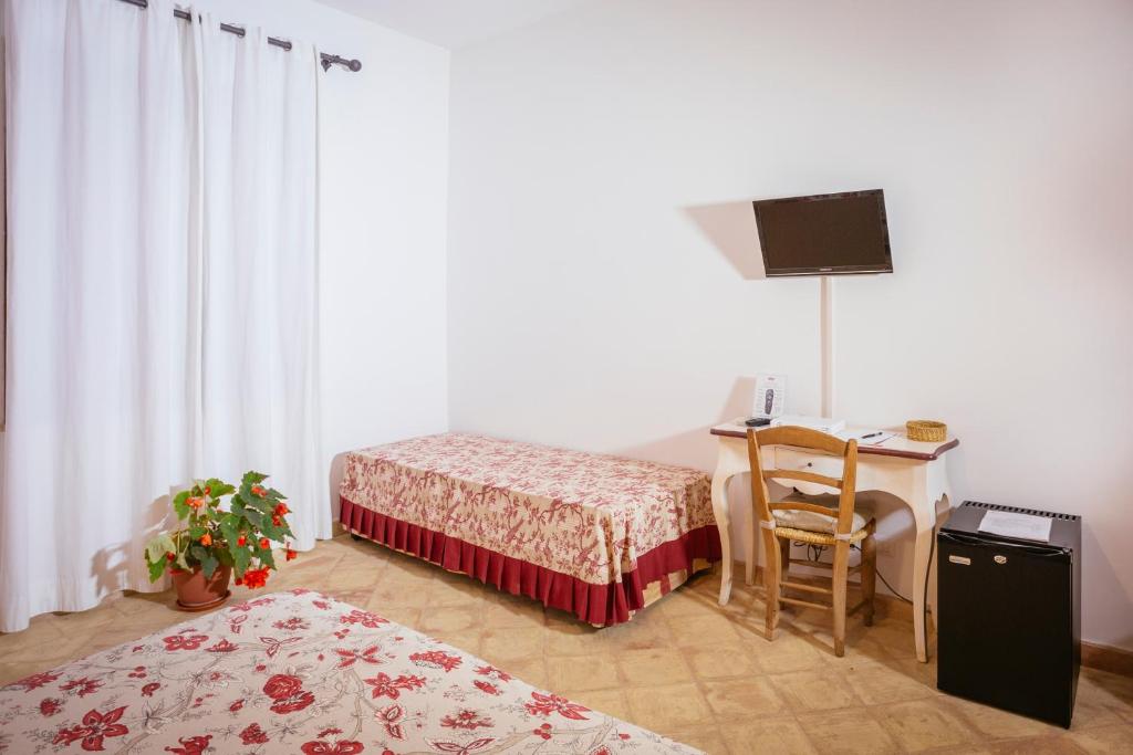 une chambre avec deux lits et un bureau avec un ordinateur dans l'établissement Hotel Baglio Catalano, à Custonaci