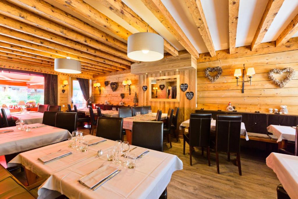 - un restaurant avec des tables, des chaises et des murs en bois dans l'établissement Hôtel Les Airelles, à La Clusaz