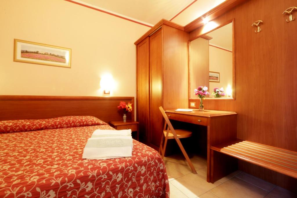 une chambre d'hôtel avec un lit, un bureau et un miroir dans l'établissement Resort Sciabache, à Zambrone