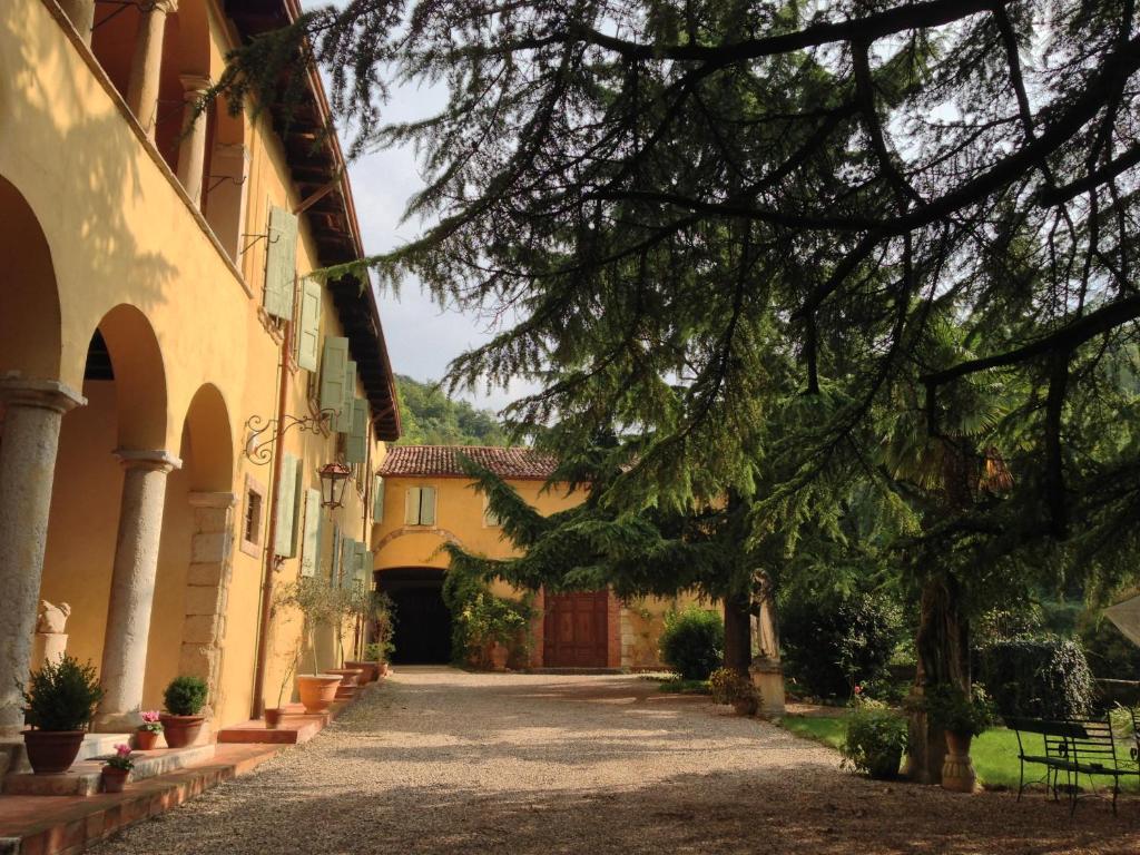 une allée entre deux bâtiments avec un arbre dans l'établissement Villa Sogara, à San Martino Buon Albergo