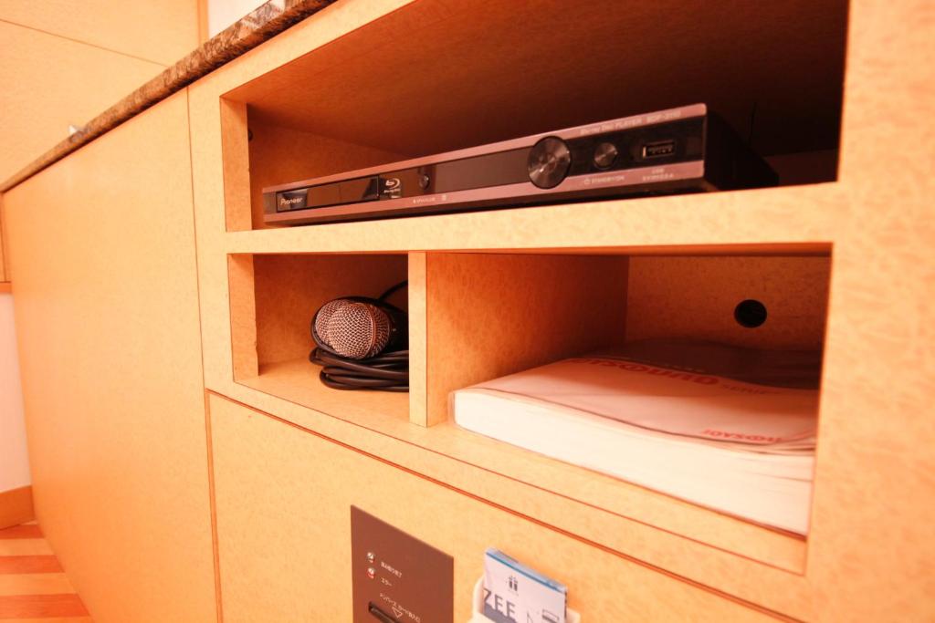 d'une armoire en bois avec un lecteur DVD. dans l'établissement HOTEL ATLAS Shinkabukicho (Adult Only), à Tokyo