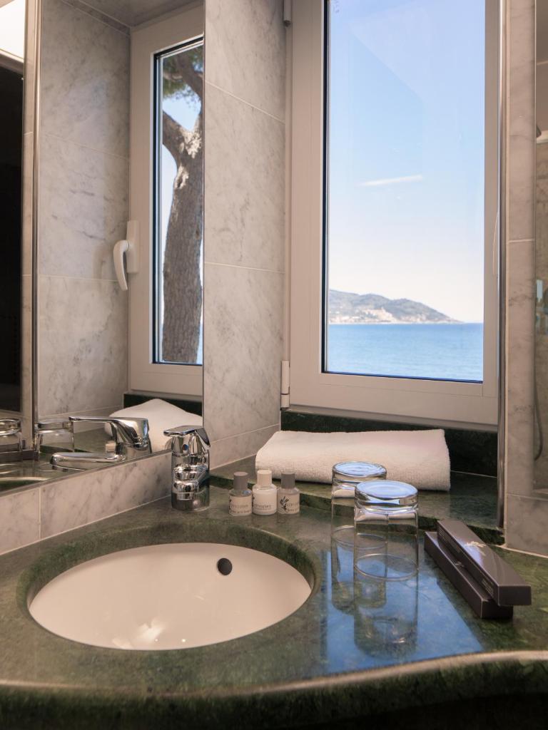 une salle de bain avec un lavabo et une grande fenêtre dans l'établissement Hotel Arc En Ciel, à Diano Marina
