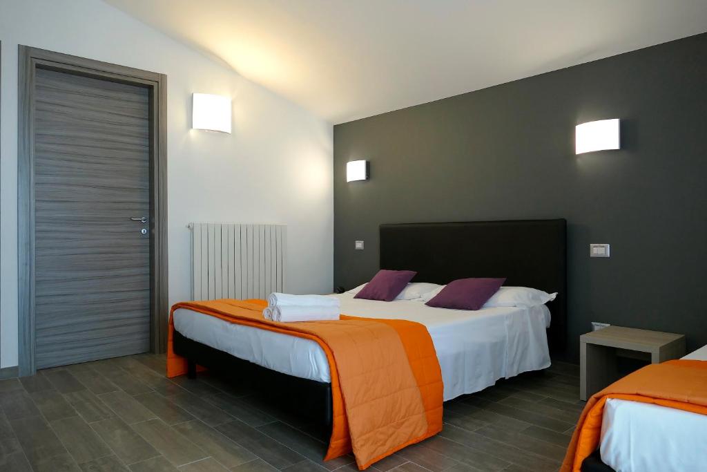 - une chambre d'hôtel avec 2 lits orange et blanc dans l'établissement Hotel Désirée, à San Benedetto del Tronto