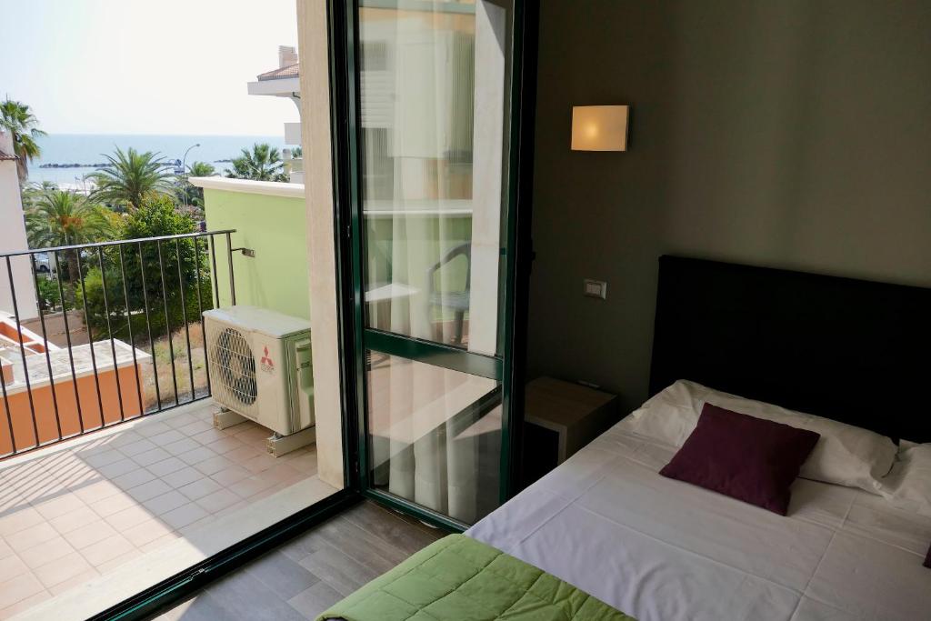 une chambre avec un lit et un balcon dans l'établissement Hotel Désirée, à San Benedetto del Tronto 74 autres photos