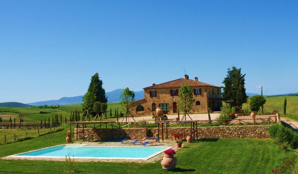 une maison avec une piscine devant une cour dans l'établissement Il Poggio, à Montisi
