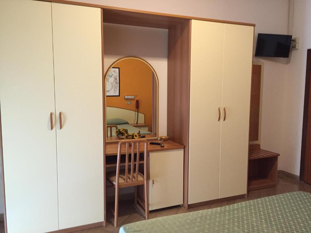 - une chambre avec un bureau et un miroir dans l'établissement Hotel Cannes, à Bellaria-Igea Marina