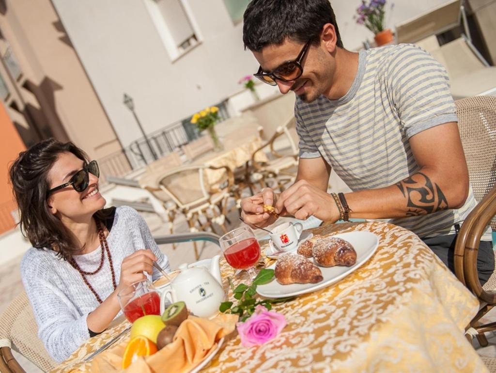 un homme et une femme assis à une table en train de manger dans l'établissement Hotel Cannes, à Bellaria-Igea Marina