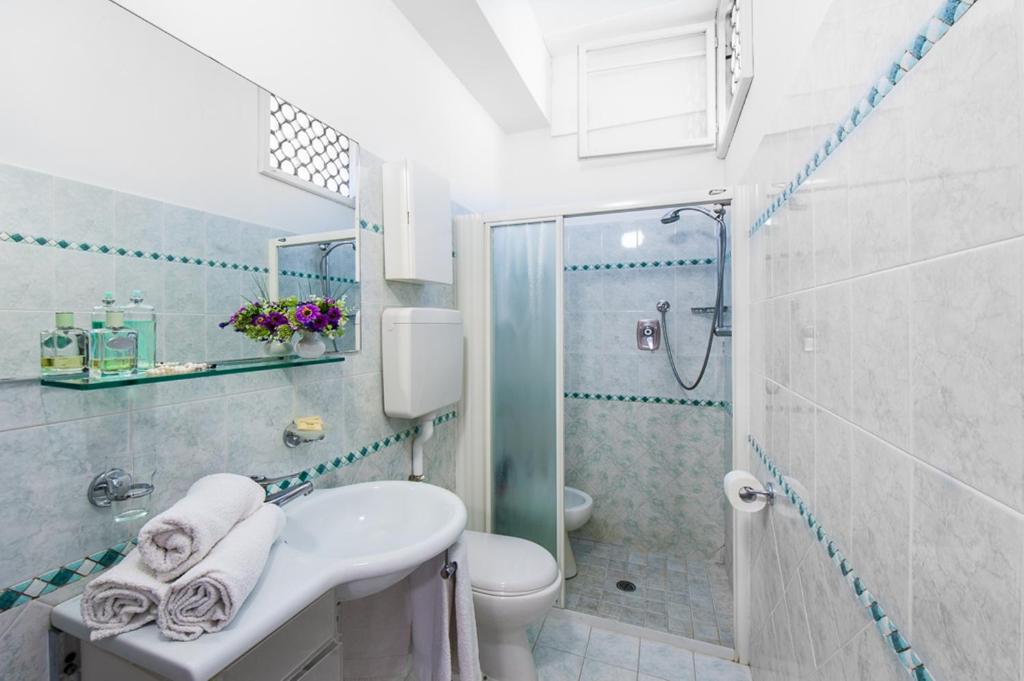 une salle de bain avec un lavabo, des toilettes et une douche dans l'établissement Hotel Cannes, à Bellaria-Igea Marina