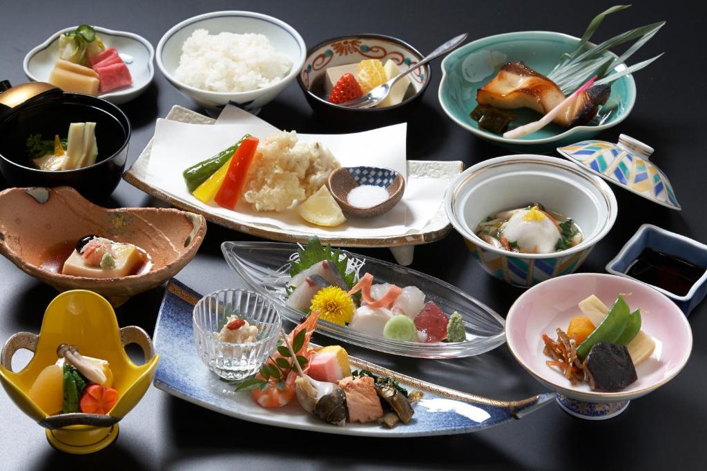 une table avec des assiettes et des bols de nourriture dans l'établissement Shitanda, à Takayama 34 autres photos