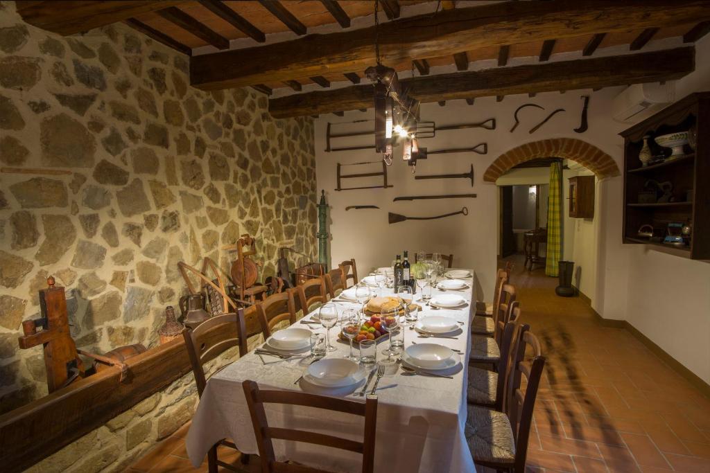 une salle à manger avec une longue table et des chaises dans l'établissement Tenuta Angelici Winery Agriturismo Henni with pool sauna and jacuzzi Cortona, à Cortone
