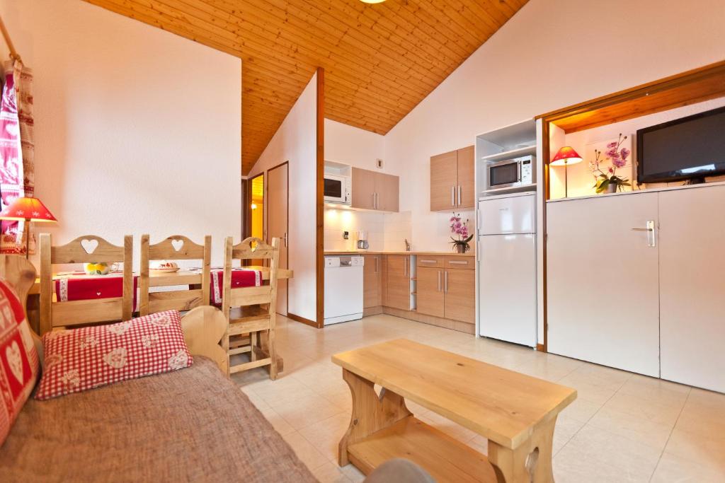 une cuisine et un salon avec un canapé et une table dans l'établissement Azureva La Clusaz les Aravis, à La Clusaz
