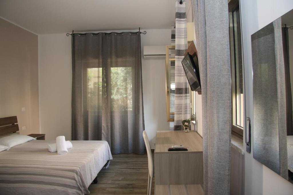 une chambre avec un lit, un bureau et une fenêtre dans l'établissement ChrisMare Hotel, à Mazzeo 182 autres photos