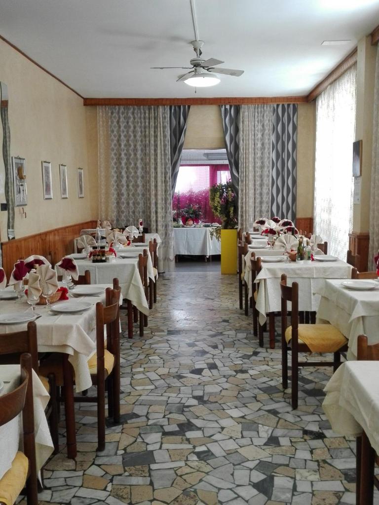 une salle à manger avec des tables et des chaises blanches dans l'établissement Villa Lavinia, à Rimini