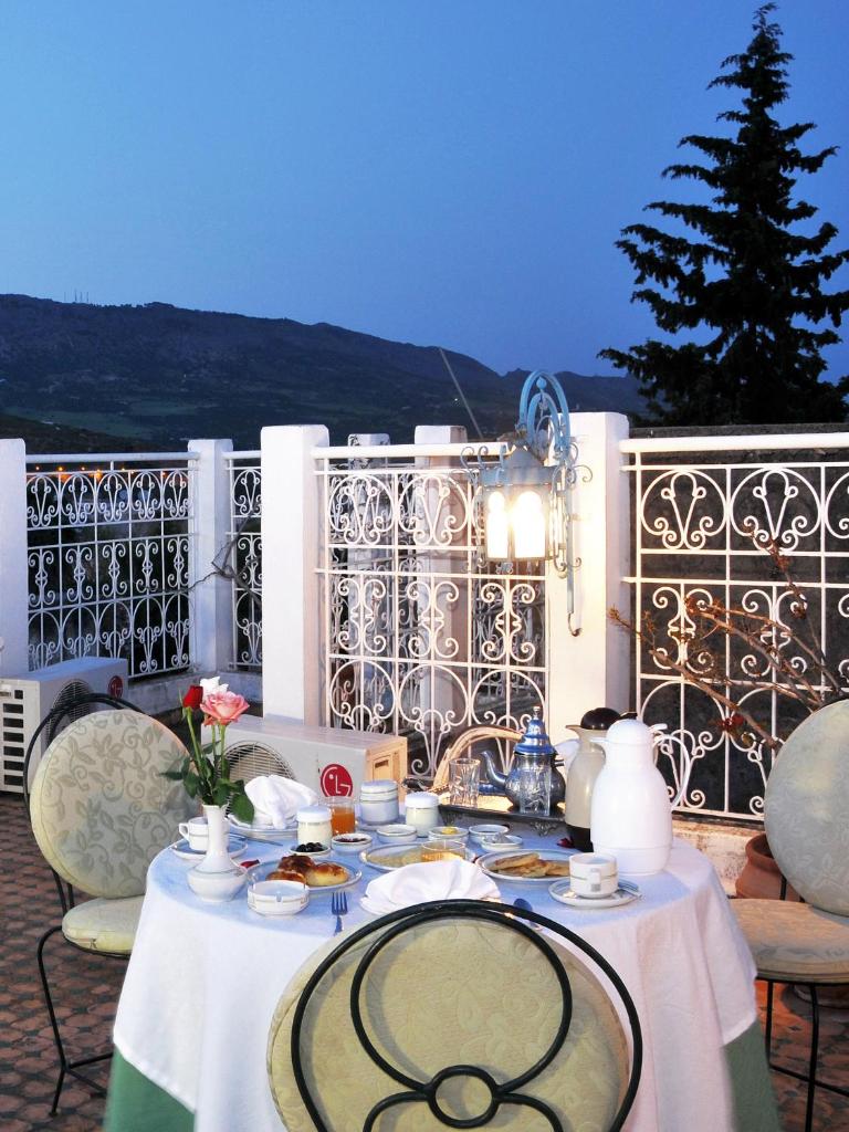 une table avec un chiffon de table blanc sur un balcon dans l'établissement Riad Myra, à Fès
