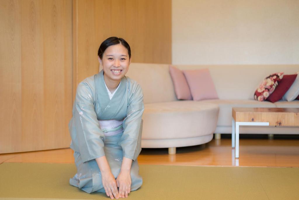 - une femme s'agenouillant sur un tapis dans un salon dans l'établissement Honjin Hiranoya Kachoan, à Takayama 37 autres photos