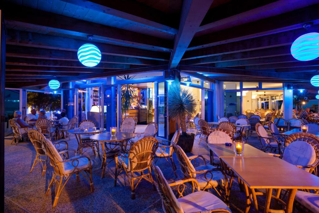un restaurant avec des tables, des chaises et des lumières dans l'établissement Hotel Playa e Mare Nostrum, à Caorle