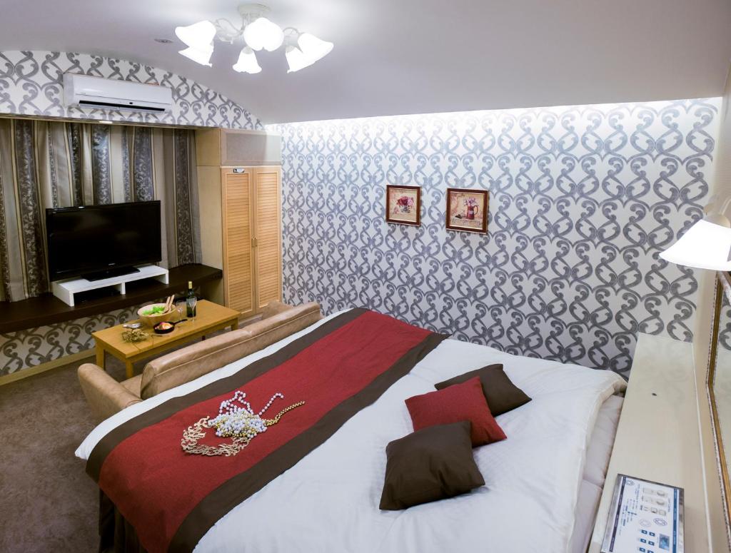 une chambre avec un grand lit et une télévision à écran plat dans l'établissement Kumamoto Hotel Christmas Forest Garden (Love Hotel), à Shimo-koga