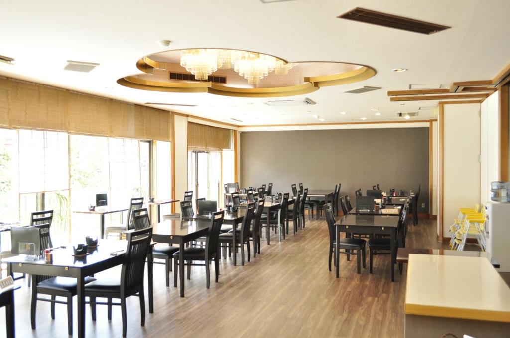 une salle à manger avec tables et chaises et un lustre dans l'établissement Kiso Mikawaya, à Kiso