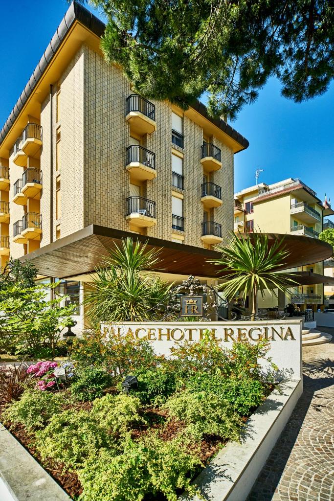 un bâtiment avec une enseigne devant lui dans l'établissement Palace Hotel Regina, à Bibione