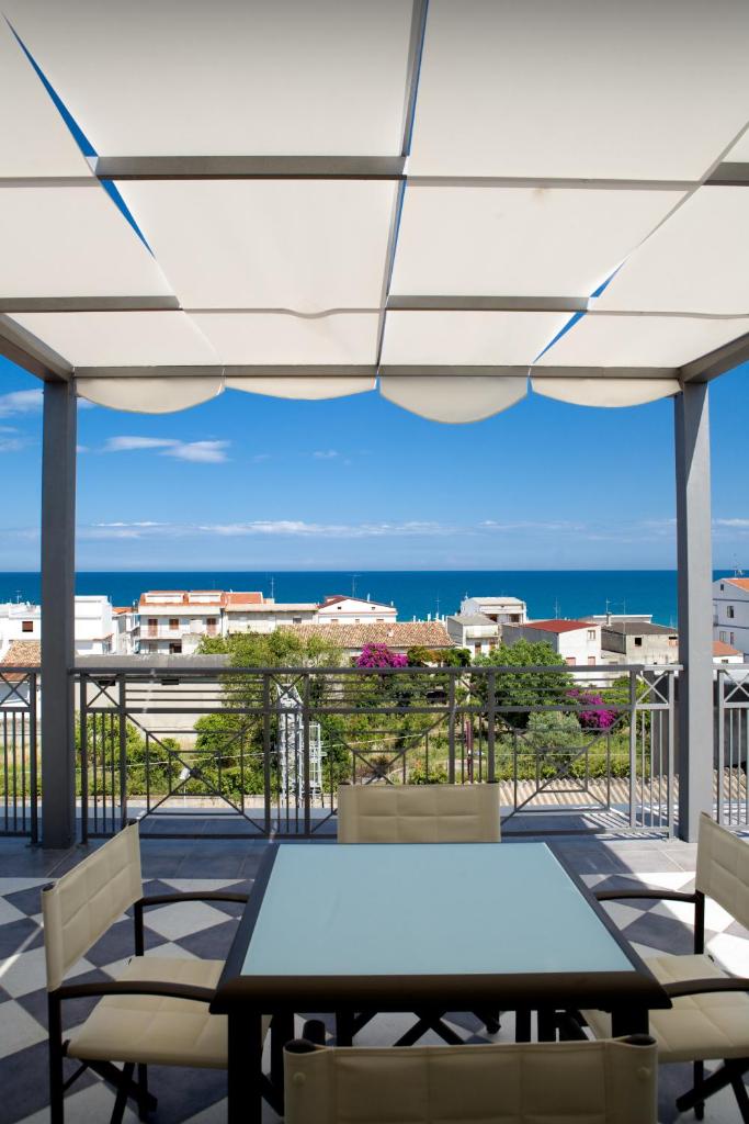 une table et des chaises sur un balcon avec vue sur l'océan dans l'établissement Hotel Napoleon, à Torre Melissa