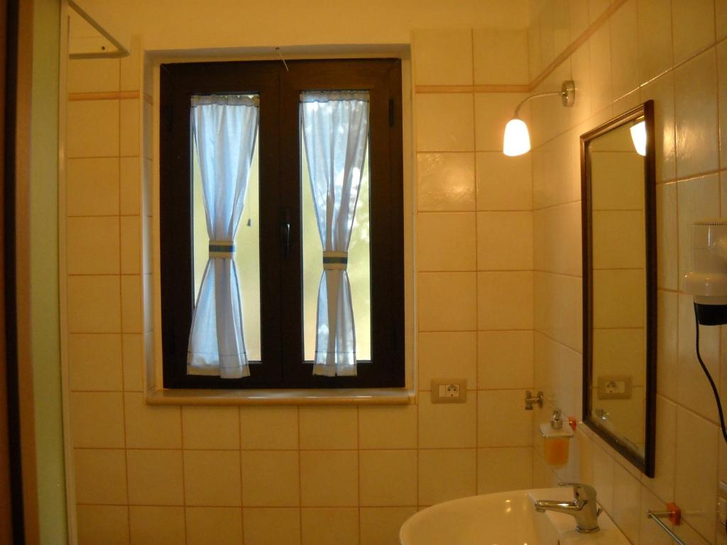 une salle de bain avec un lavabo et une fenêtre dans l'établissement Zagare Residence, à Rodi Garganico