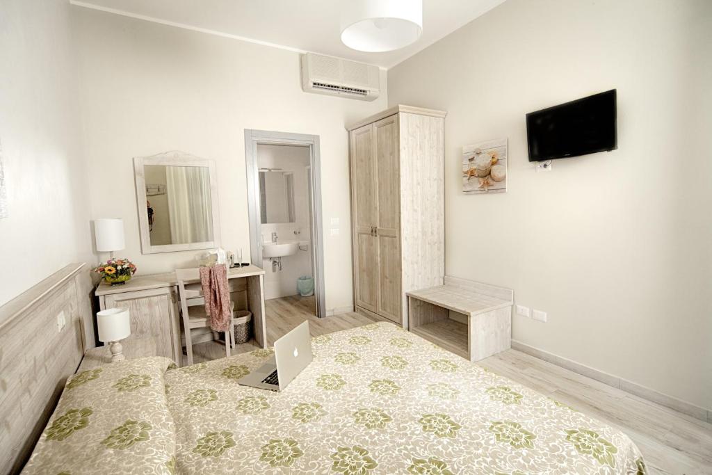 une chambre avec un lit et un bureau avec un ordinateur portable dans l'établissement Il Lido, à Giannella