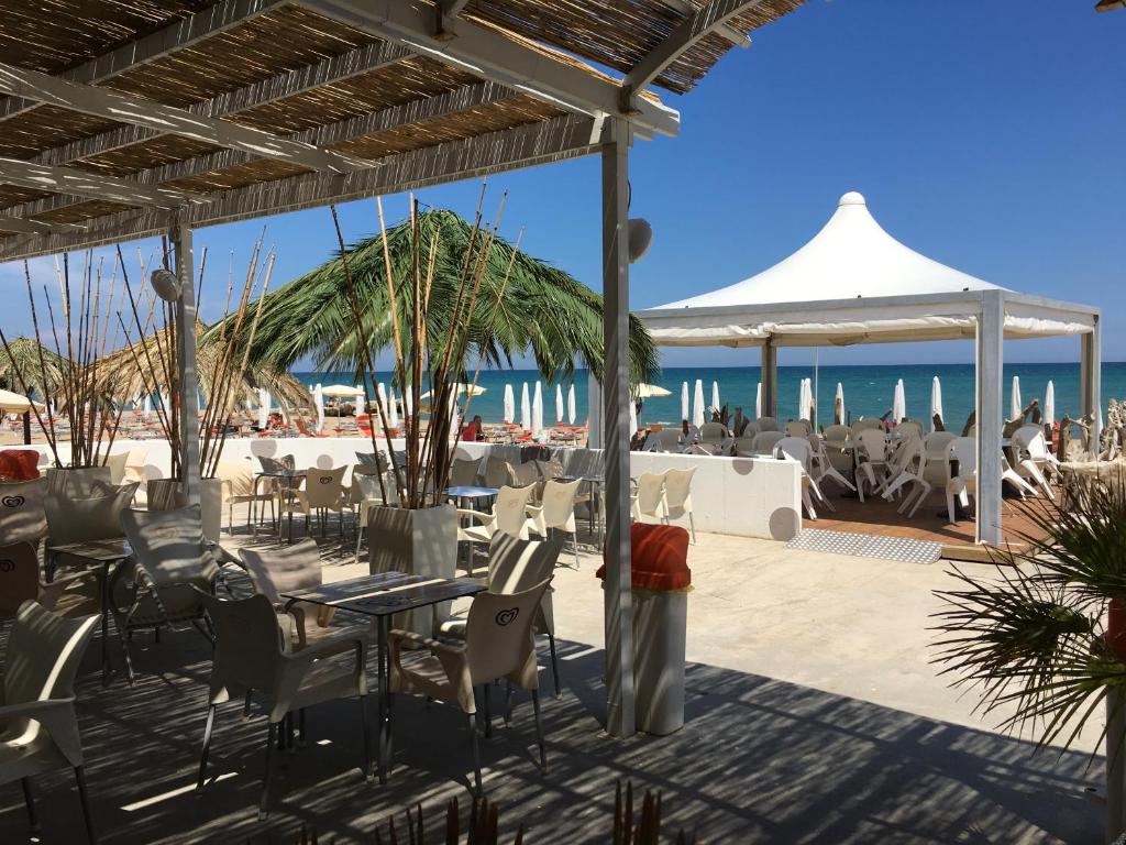 - un restaurant sur la plage avec l'océan en arrière-plan dans l'établissement Residenza Ondanomala, à Chieuti