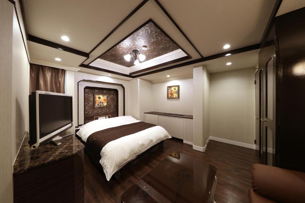 une chambre avec un lit et une télévision à écran plat dans l'établissement Hotel Fine Shiga Ritto, à Ritto