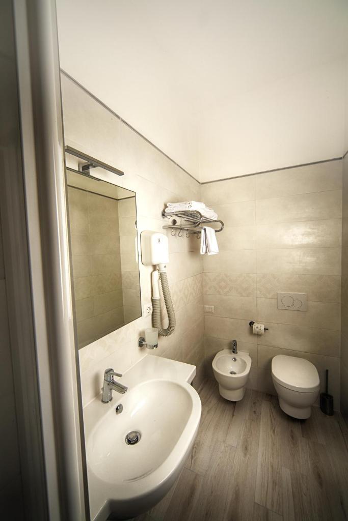 une salle de bain avec un lavabo et des toilettes dans l'établissement Il Lido, à Giannella 64 autres photos