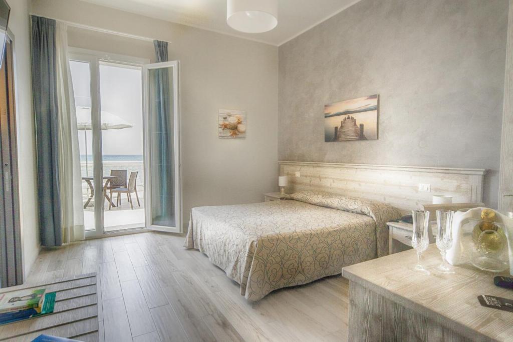 une chambre avec un lit et une vue sur l'océan dans l'établissement Il Lido, à Giannella