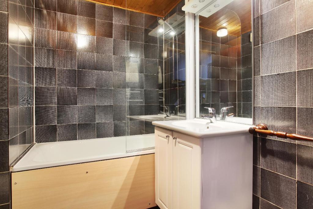 une salle de bain avec une douche, un lavabo et une baignoire dans l'établissement Résidence Odalys Le Front de Neige, aux Carroz d'Arâches