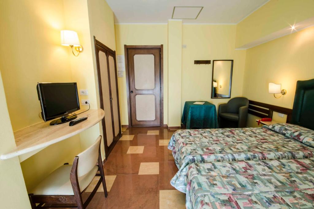 une chambre d'hôtel avec un lit et une télévision à écran plat dans l'établissement Hotel Tarconte, à Tarquinia