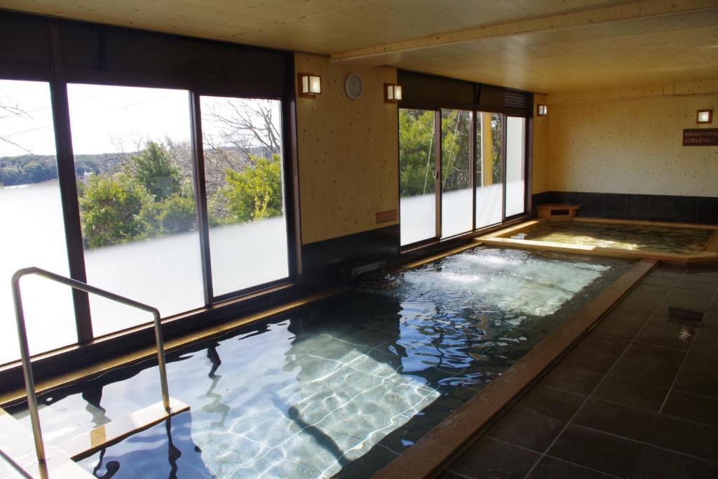 une grande piscine intérieure avec fenêtres dans un bâtiment dans l'établissement Kashikojima Park Hotel Michishio, à Shima 37 autres photos