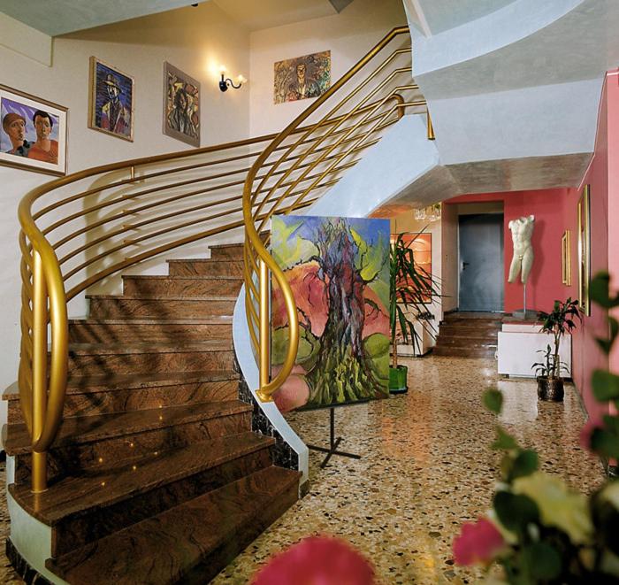 un escalier dans un bâtiment avec une peinture murale dans l'établissement Hotel Miramare, à Bibione