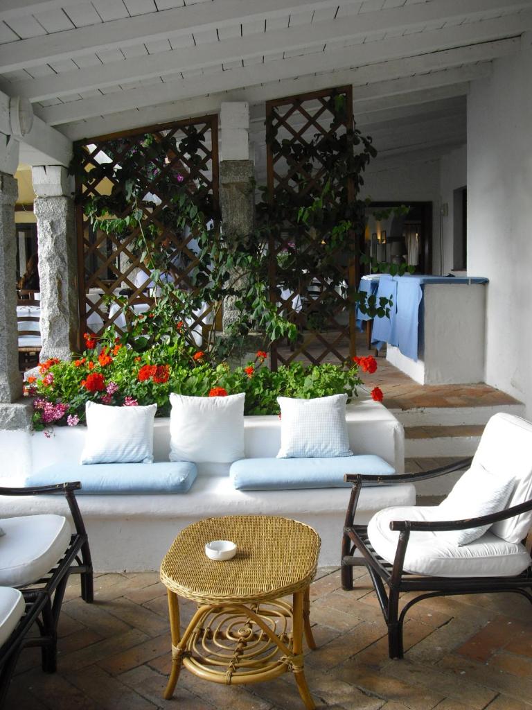 une terrasse avec des canapés blancs, une table et des chaises dans l'établissement IHR Hotel San Paolo, à Porto San Paolo